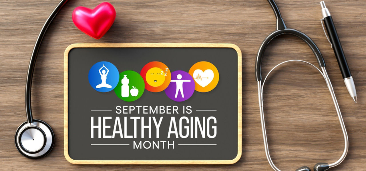 september is healthy aging month. stethoscope heart balloon pen